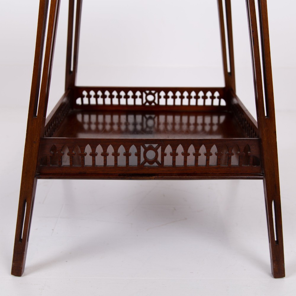 A late Victorian two-tier walnut side table featuring square splayed legs and a lower shelf enclosed by a pierced fretwork gallery. View IV