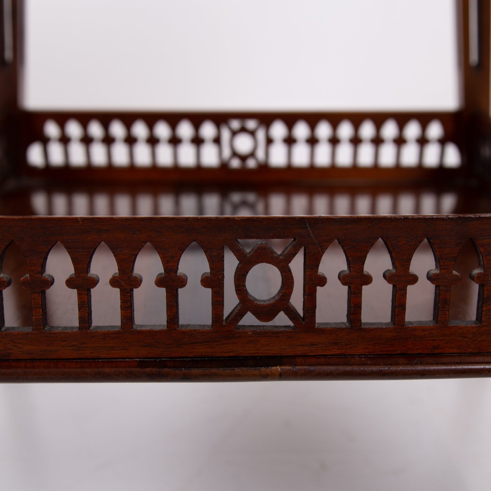 A late Victorian two-tier walnut side table featuring square splayed legs and a lower shelf enclosed by a pierced fretwork gallery. View V