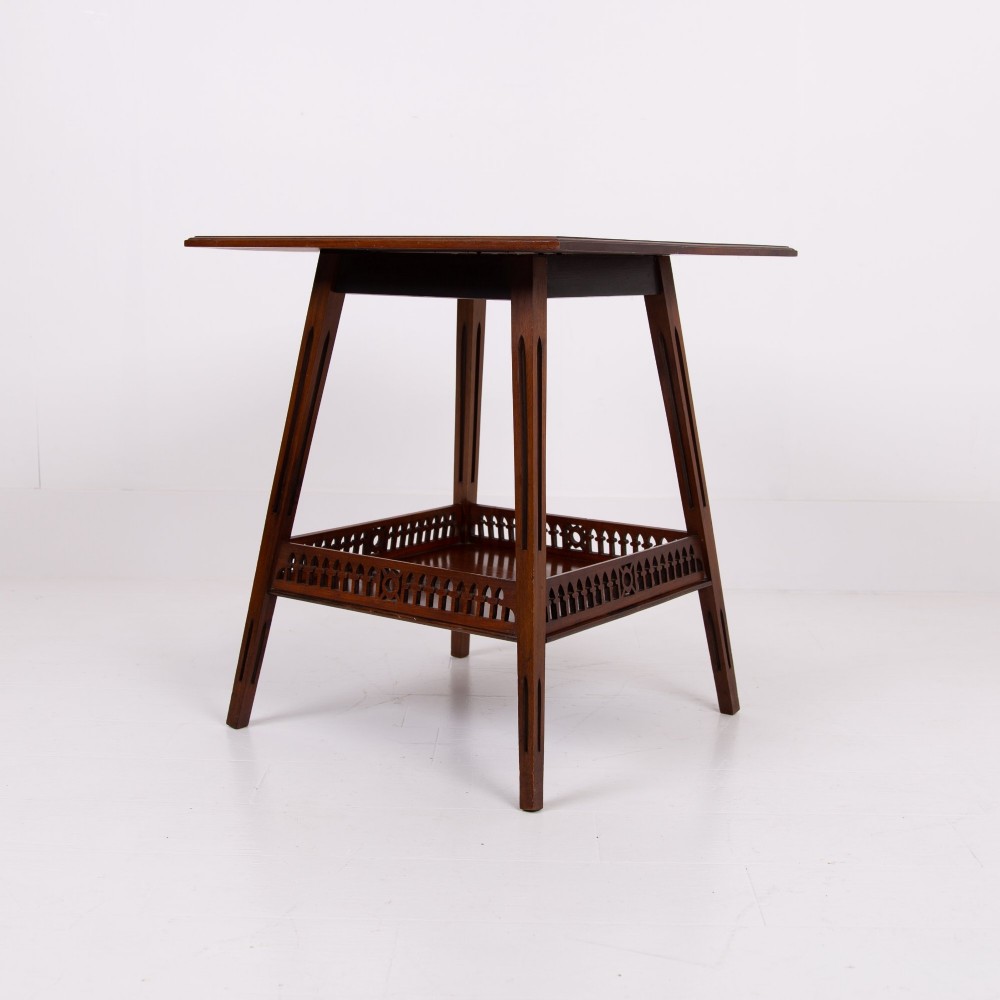 A late Victorian two-tier walnut side table featuring square splayed legs and a lower shelf enclosed by a pierced fretwork gallery. View VII