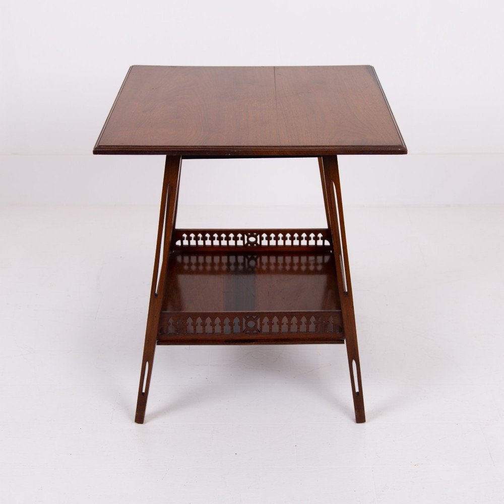 A late Victorian two-tier walnut side table featuring square splayed legs and a lower shelf enclosed by a pierced fretwork gallery. View XI