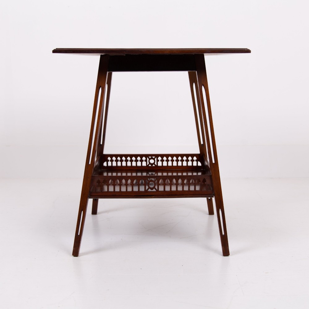 A late Victorian two-tier walnut side table featuring square splayed legs and a lower shelf enclosed by a pierced fretwork gallery. View XII