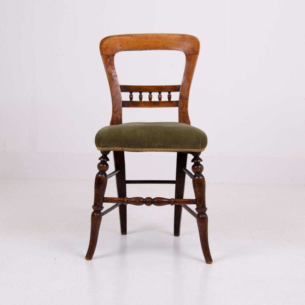 A set of six late Victorian wooden dining chairs featuring curved open backrests with spindle galleries, turned front legs, and olive green velvet seats. View II