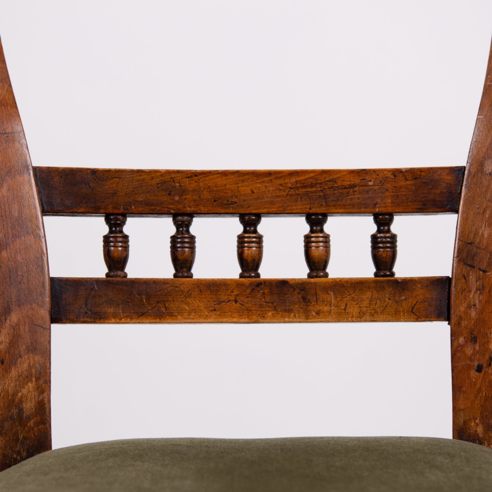 A set of six late Victorian wooden dining chairs featuring curved open backrests with spindle galleries, turned front legs, and olive green velvet seats. View III