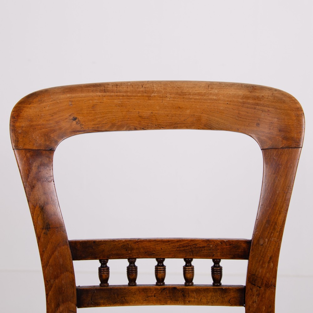 A set of six late Victorian wooden dining chairs featuring curved open backrests with spindle galleries, turned front legs, and olive green velvet seats. View VI