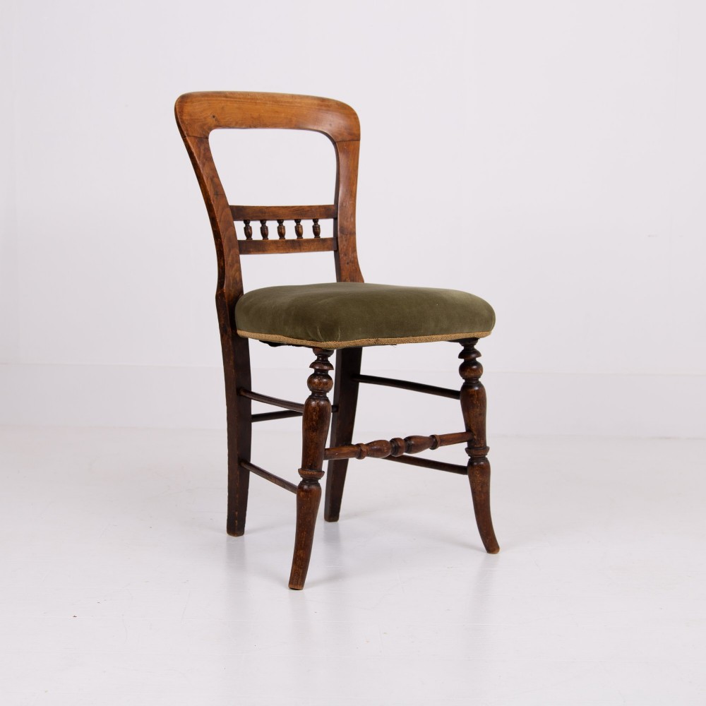 A set of six late Victorian wooden dining chairs featuring curved open backrests with spindle galleries, turned front legs, and olive green velvet seats. View VII