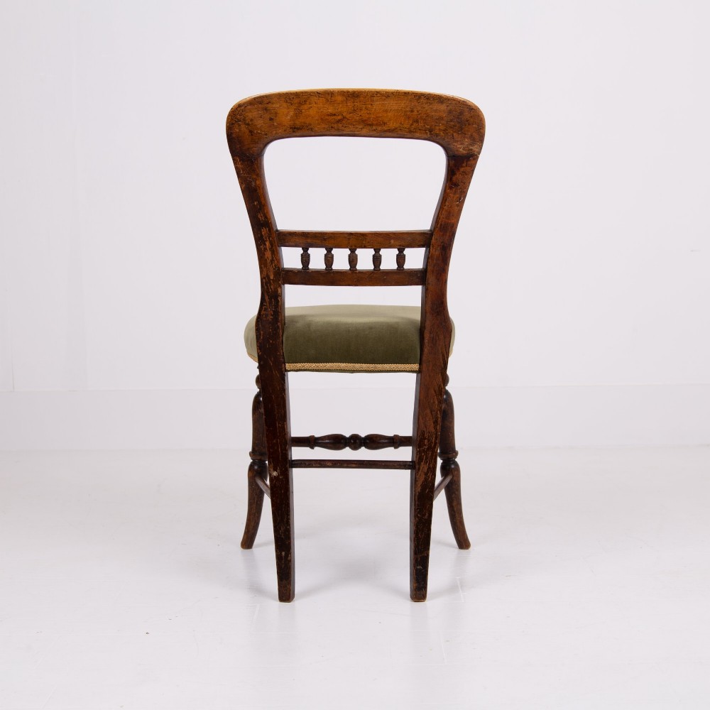 A set of six late Victorian wooden dining chairs featuring curved open backrests with spindle galleries, turned front legs, and olive green velvet seats. View VIII