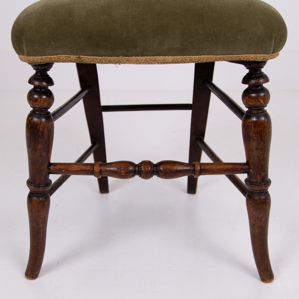 A set of six late Victorian wooden dining chairs featuring curved open backrests with spindle galleries, turned front legs, and olive green velvet seats. View IX