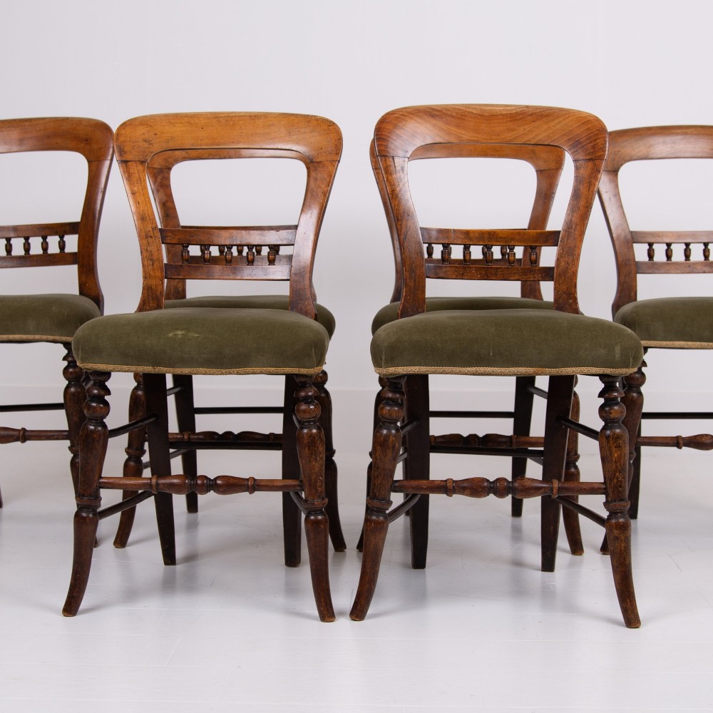 A set of six late Victorian wooden dining chairs featuring curved open backrests with spindle galleries, turned front legs, and olive green velvet seats. View XI
