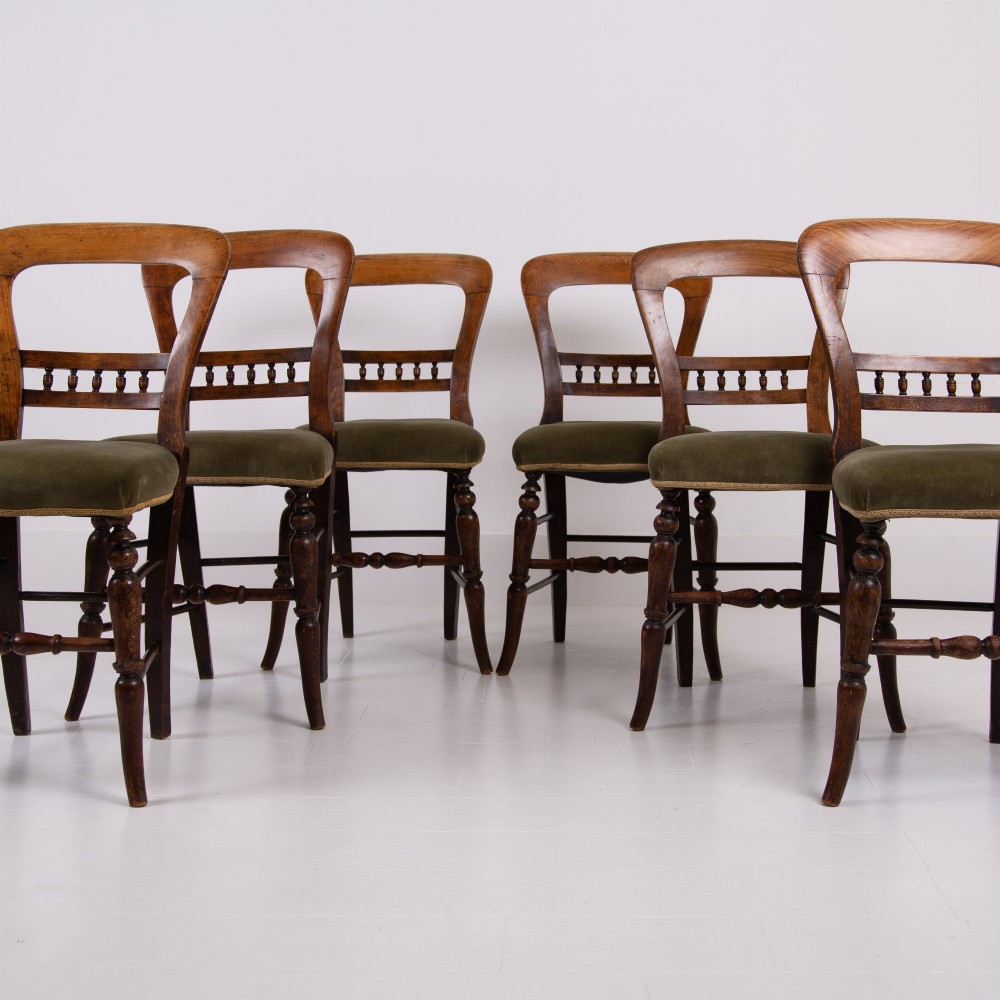 A set of six late Victorian wooden dining chairs featuring curved open backrests with spindle galleries, turned front legs, and olive green velvet seats. View XIII