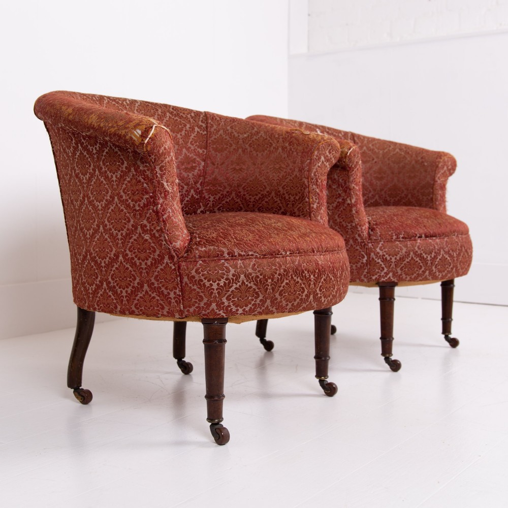 A pair of 19th-century Victorian tub armchairs upholstered in patterned red fabric with turned wooden legs on brass castors. View II