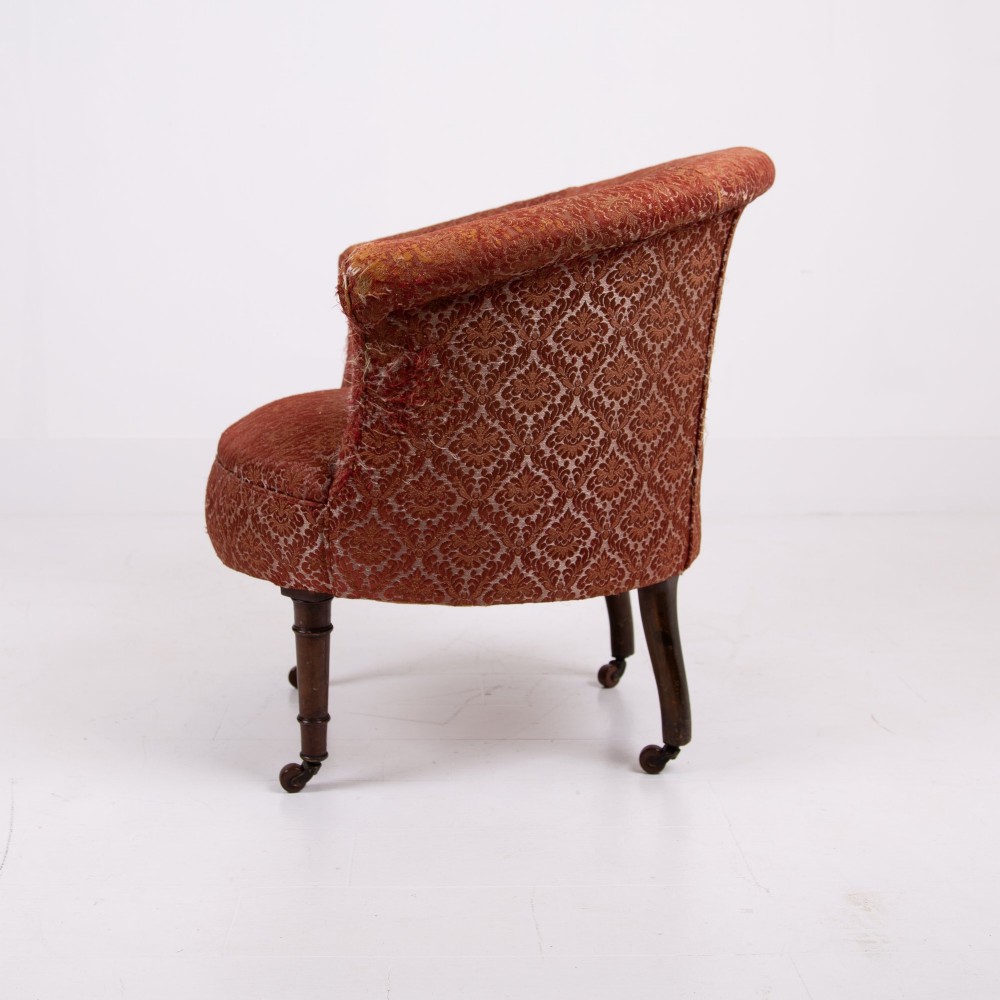 A pair of 19th-century Victorian tub armchairs upholstered in patterned red fabric with turned wooden legs on brass castors. View IV