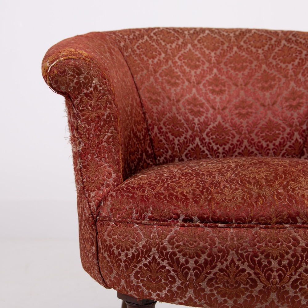 A pair of 19th-century Victorian tub armchairs upholstered in patterned red fabric with turned wooden legs on brass castors. View VII