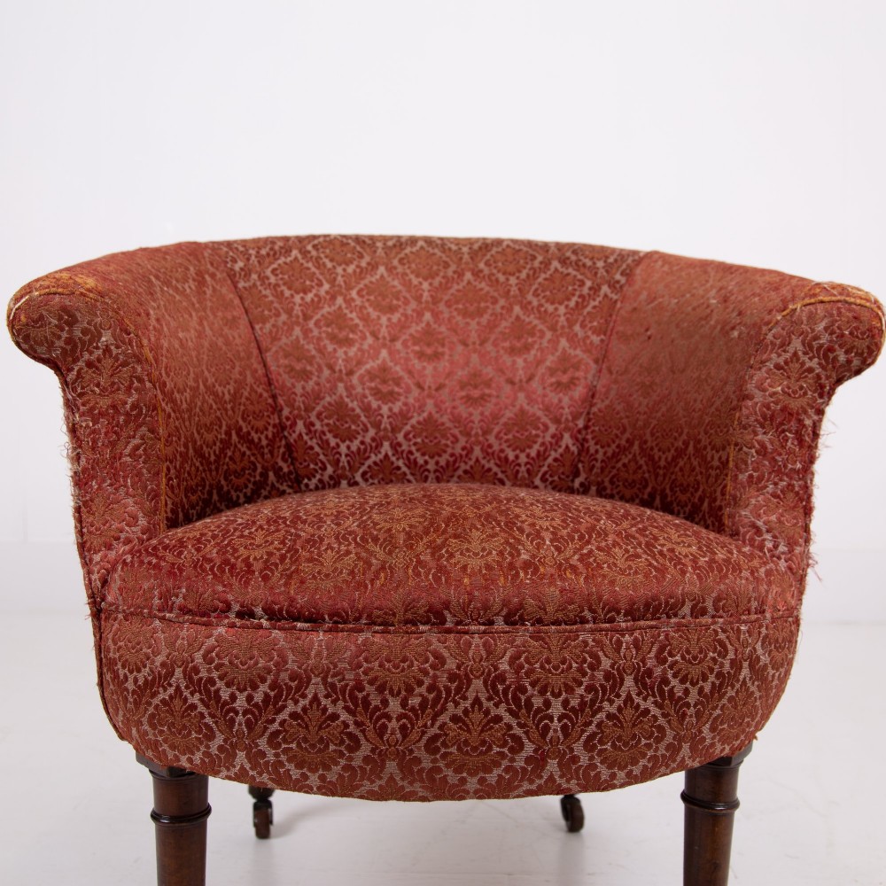 A pair of 19th-century Victorian tub armchairs upholstered in patterned red fabric with turned wooden legs on brass castors. View VIII