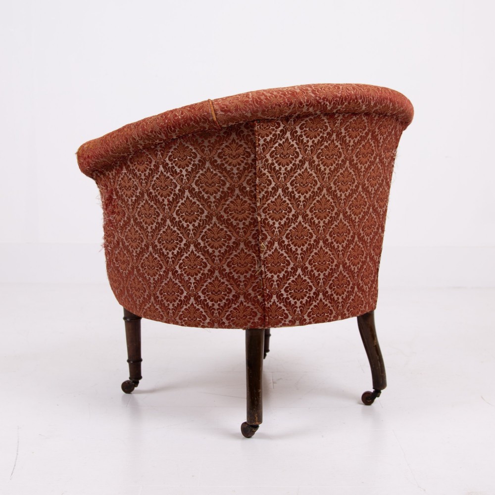 A pair of 19th-century Victorian tub armchairs upholstered in patterned red fabric with turned wooden legs on brass castors. View XII