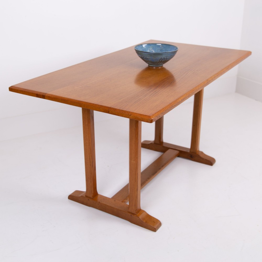 A 1930s Heals oak dining table featuring a rectangular solid timber top supported by a double-upright trestle base.