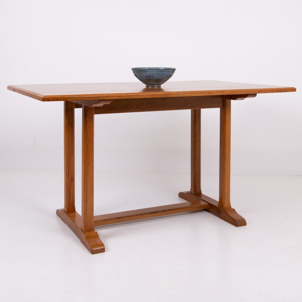 A 1930s Heals oak dining table featuring a rectangular solid timber top supported by a double-upright trestle base. View II