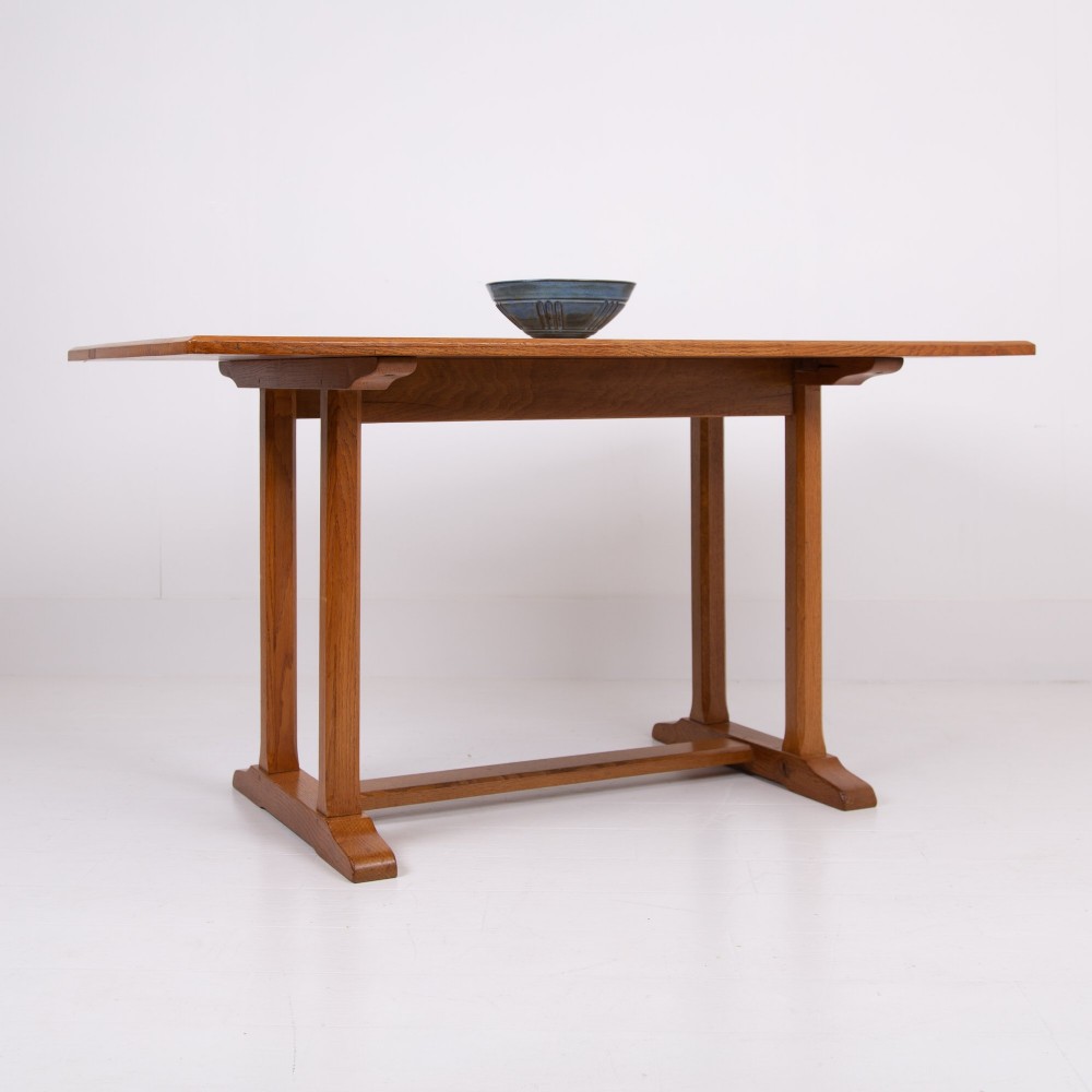 A 1930s Heals oak dining table featuring a rectangular solid timber top supported by a double-upright trestle base. View XIV