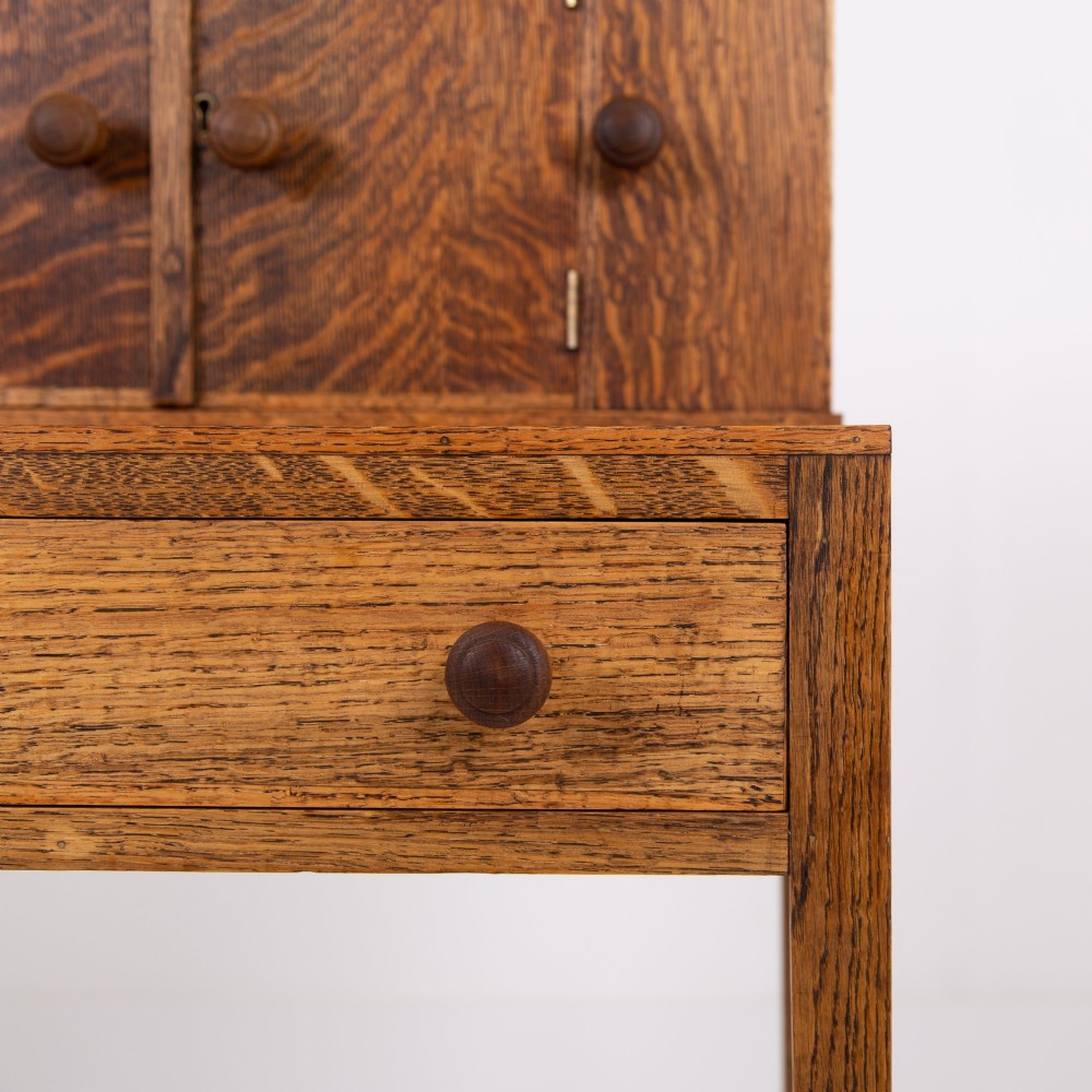 A 1930s warm brown oak writing desk featuring a top compartment with cupboard doors, side fold-out sections, and a single drawer on square legs. View VIII