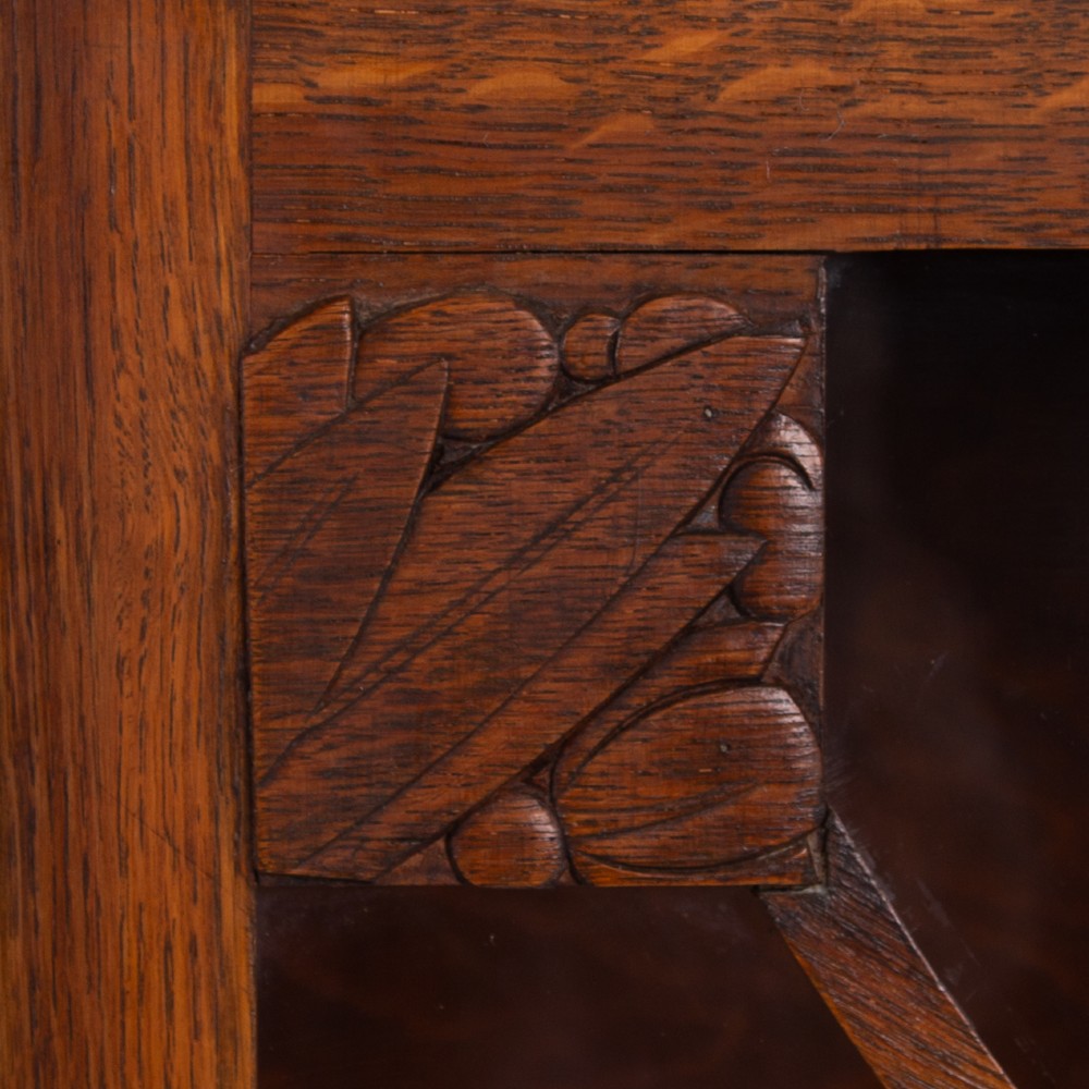 An Art Deco medium oak glazed bookcase featuring twin doors with decorative geometric wooden glazing bars and squat turned feet. View V