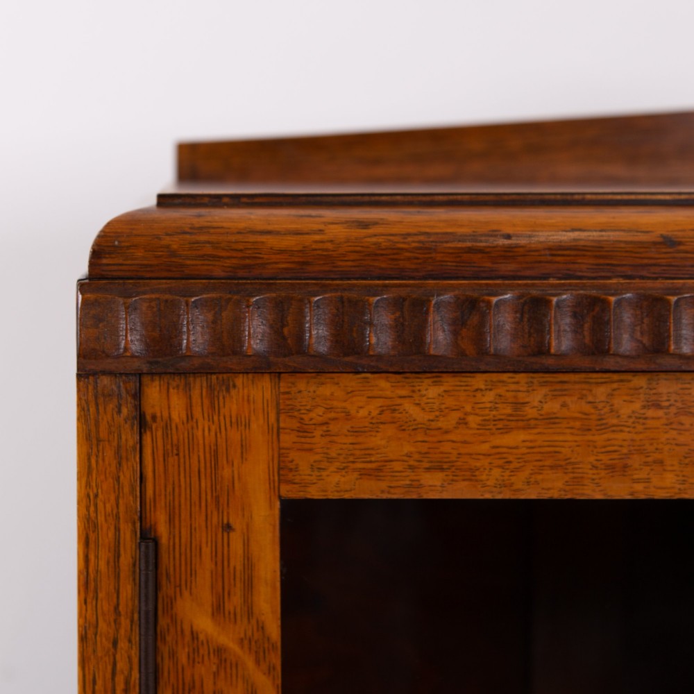 An Art Deco medium oak glazed bookcase featuring twin doors with decorative geometric wooden glazing bars and squat turned feet. View VIII