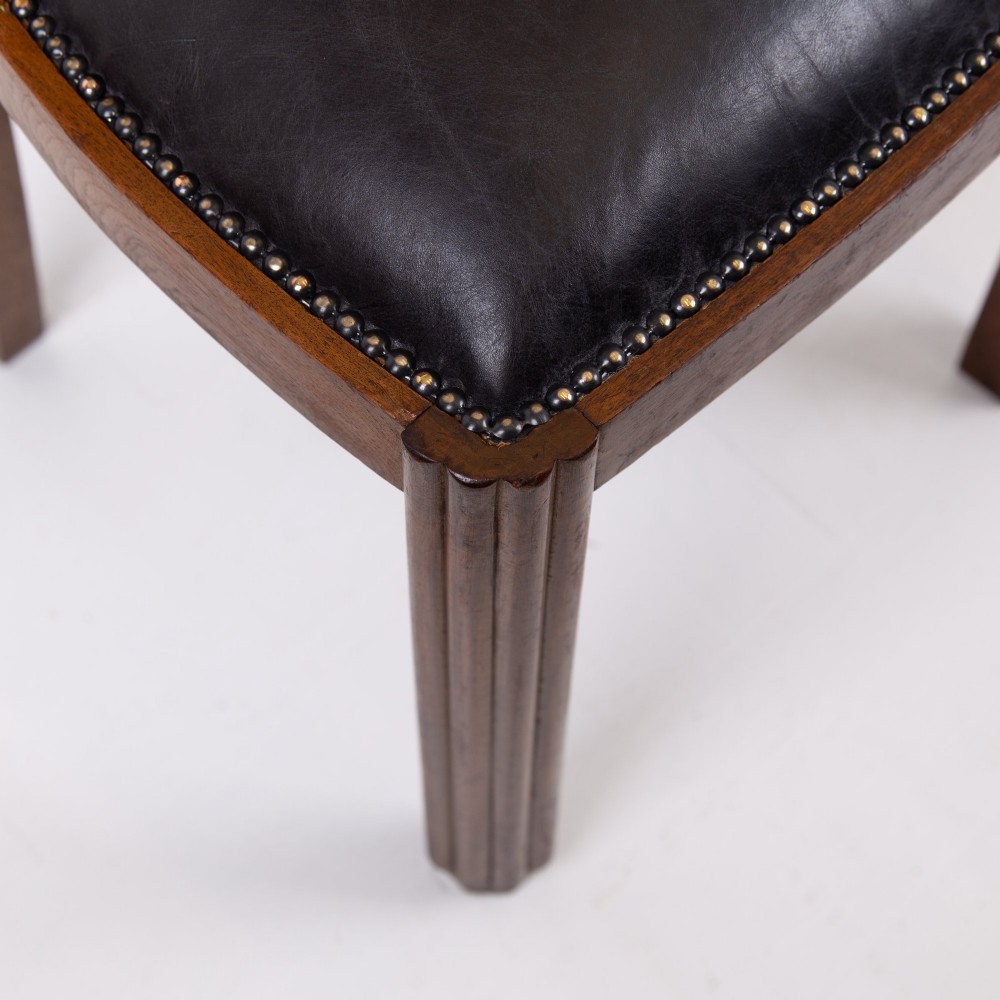 A set of four dark walnut dining chairs featuring carved sunburst motifs on the backs and dark leather upholstered seats. View VII