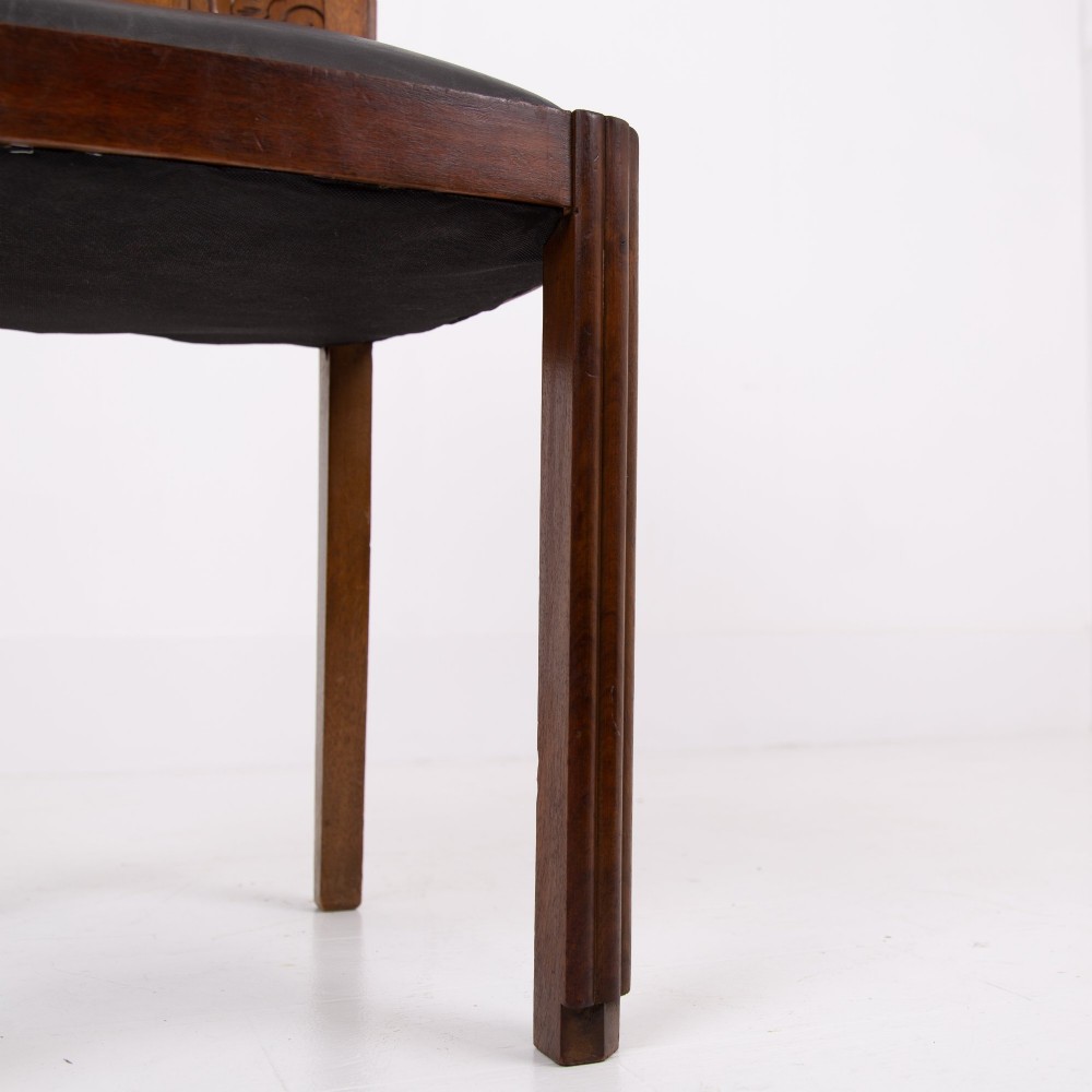 A set of four dark walnut dining chairs featuring carved sunburst motifs on the backs and dark leather upholstered seats. View IX