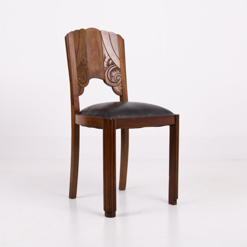 A set of four dark walnut dining chairs featuring carved sunburst motifs on the backs and dark leather upholstered seats. View XI