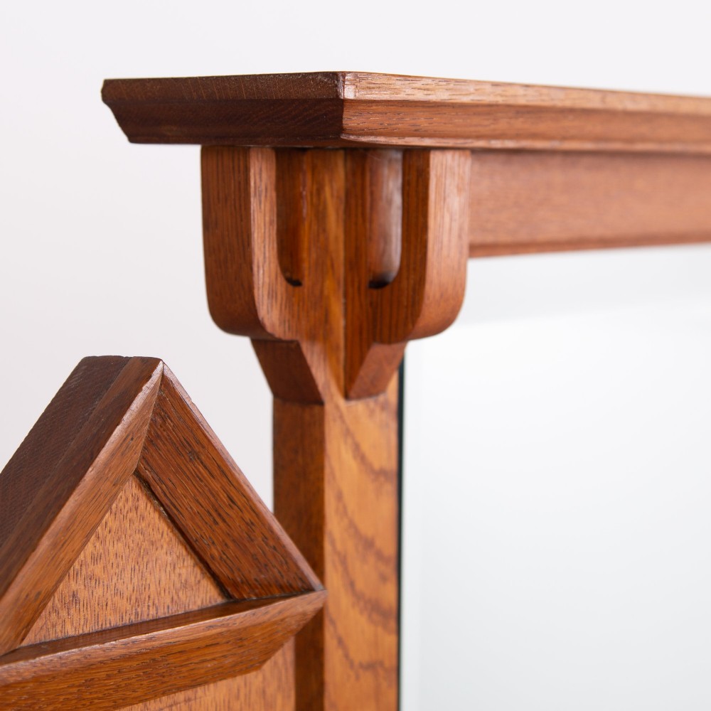 An Arts and Crafts oak dressing chest featuring a superstructure with a central mirror, inlaid side panels, and small jewellery drawers above a chest of drawers. View IV