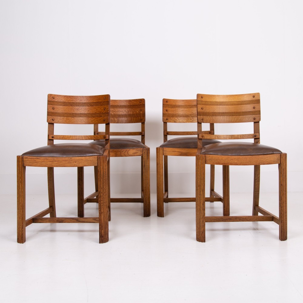 An Art Deco medium oak dining set comprising a rectangular pedestal table and four matching chairs with brown leather seats. View II