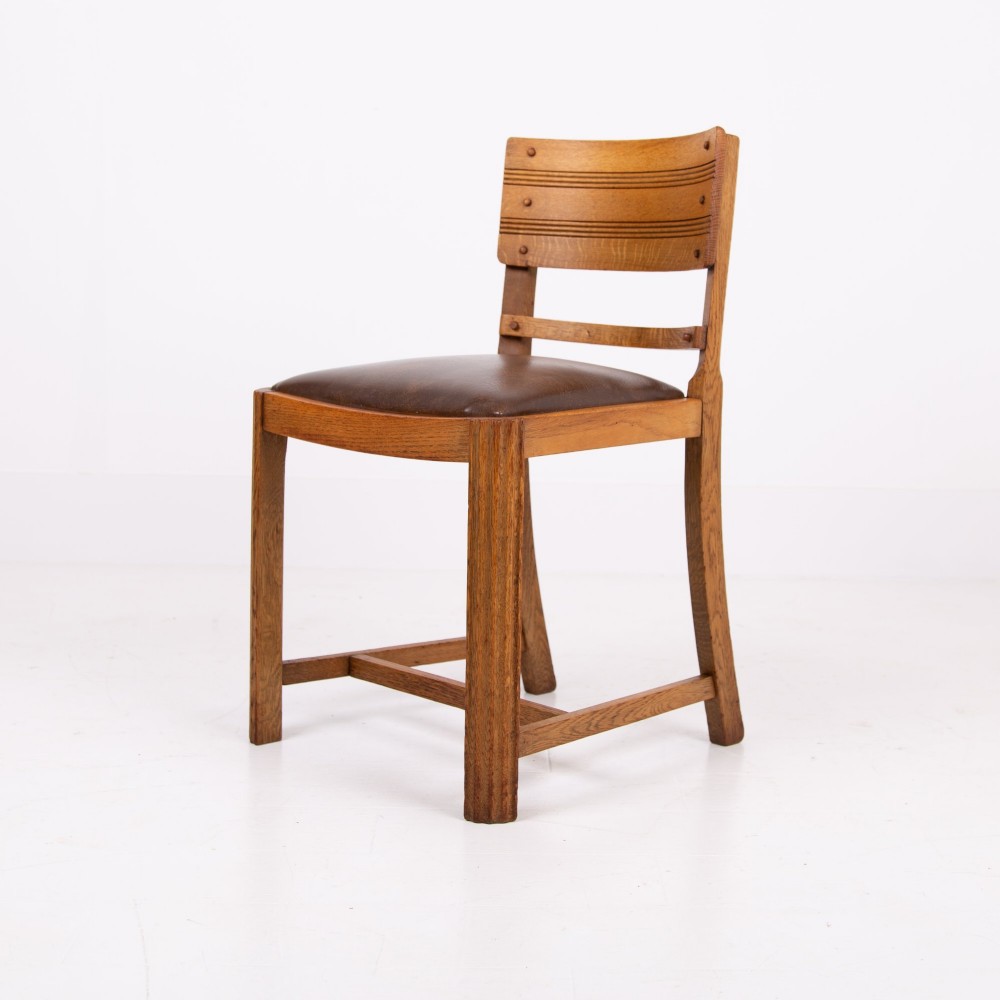 An Art Deco medium oak dining set comprising a rectangular pedestal table and four matching chairs with brown leather seats. View VI
