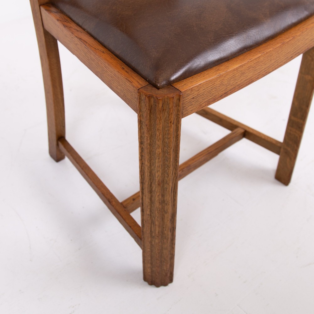 An Art Deco medium oak dining set comprising a rectangular pedestal table and four matching chairs with brown leather seats. View VIII