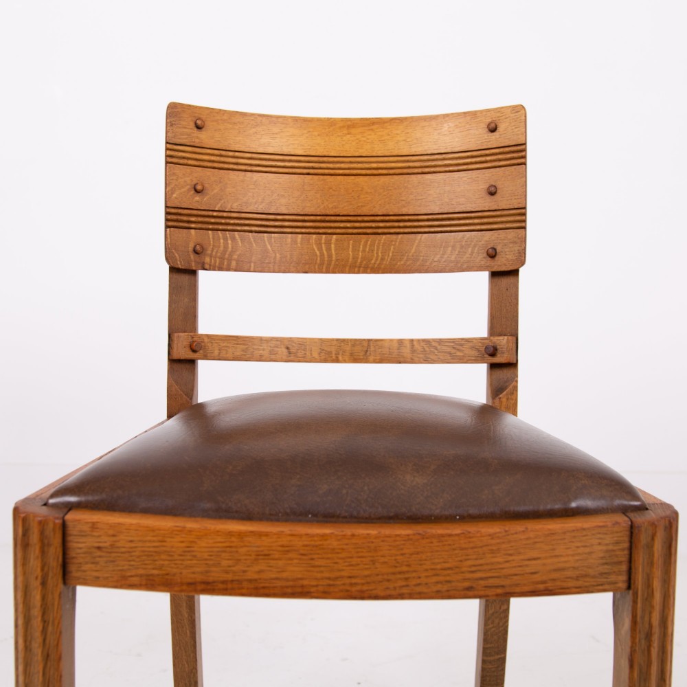An Art Deco medium oak dining set comprising a rectangular pedestal table and four matching chairs with brown leather seats. View IX