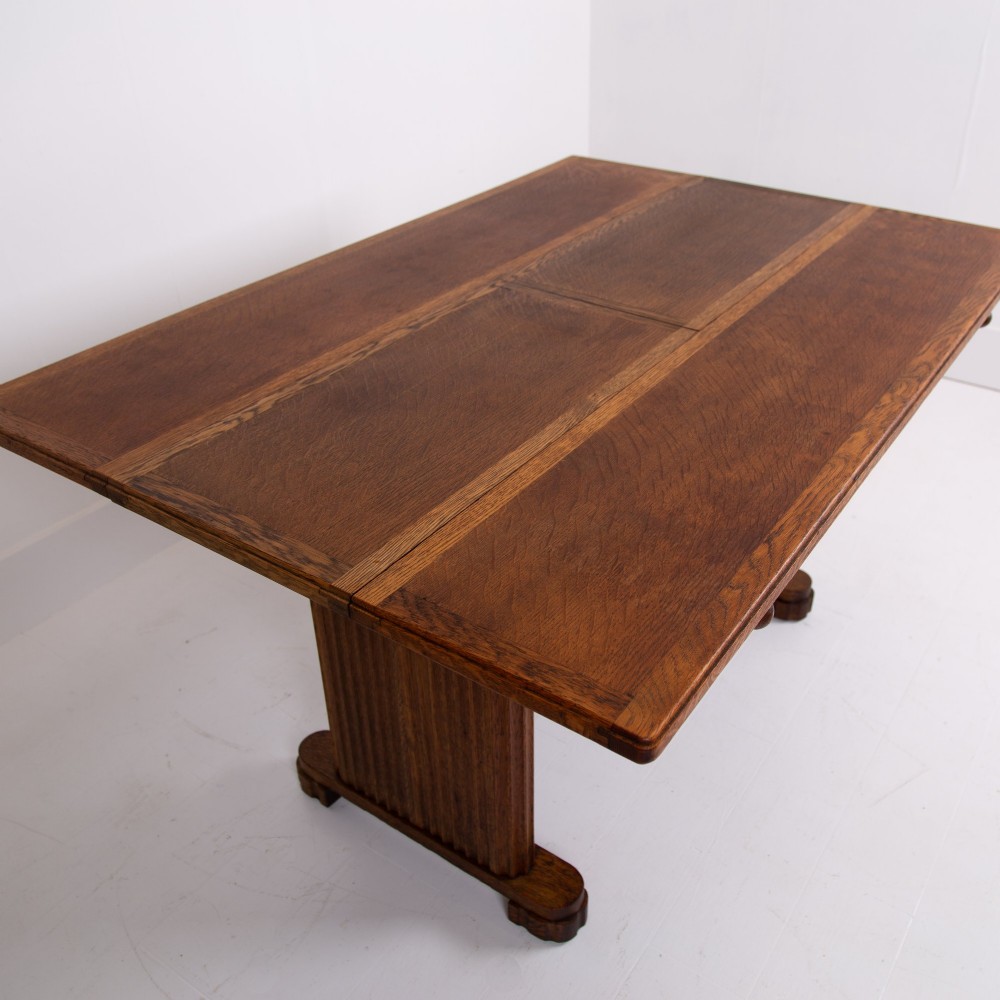 An Art Deco medium oak dining set comprising a rectangular pedestal table and four matching chairs with brown leather seats. View X