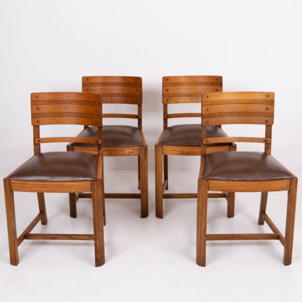 An Art Deco medium oak dining set comprising a rectangular pedestal table and four matching chairs with brown leather seats. View XIV