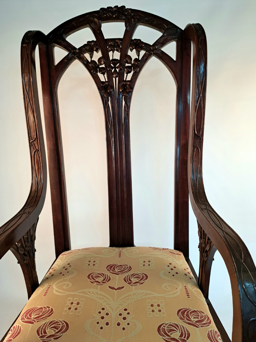 An Art Nouveau carved dark wood armchair featuring organic plant-inspired carved backrest detailing and a light green upholstered seat. View IV