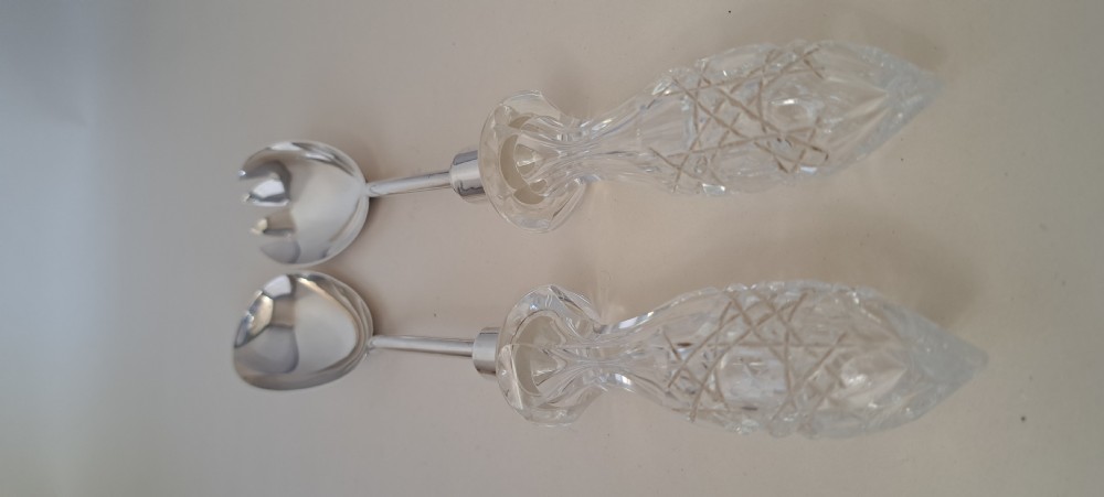 A circular cut crystal salad bowl with a silver rim, accompanied by a pair of silver and crystal-handled salad servers. View XIV