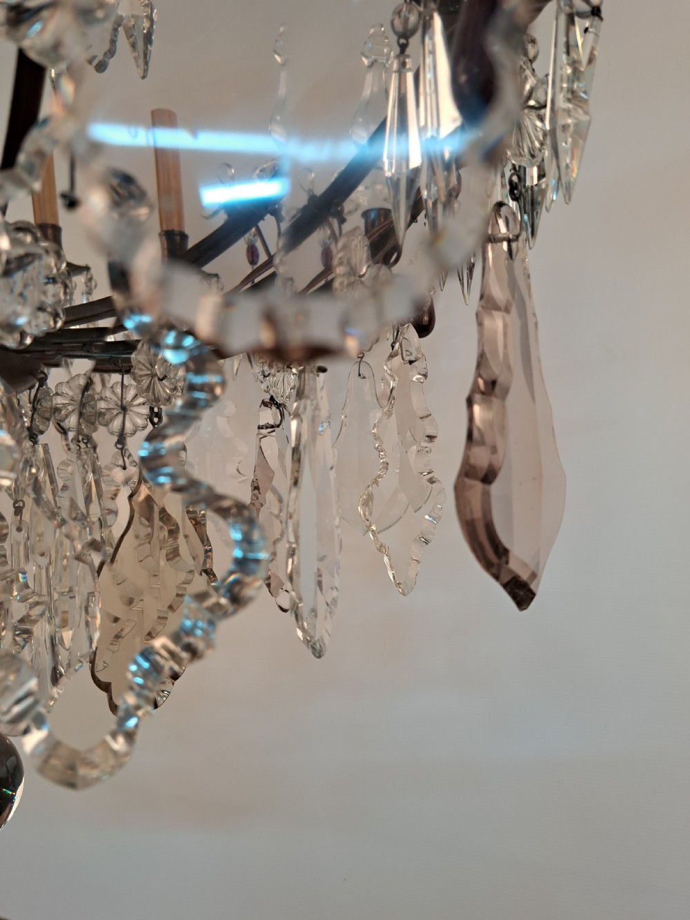 A multi-arm French crystal chandelier with candle-style light sockets, clear faceted glass prisms, and purple teardrop pendants on a dark wrought iron frame. View XI