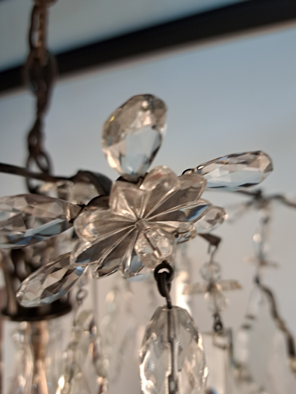 A multi-arm French crystal chandelier with candle-style light sockets, clear faceted glass prisms, and purple teardrop pendants on a dark wrought iron frame. View XVII