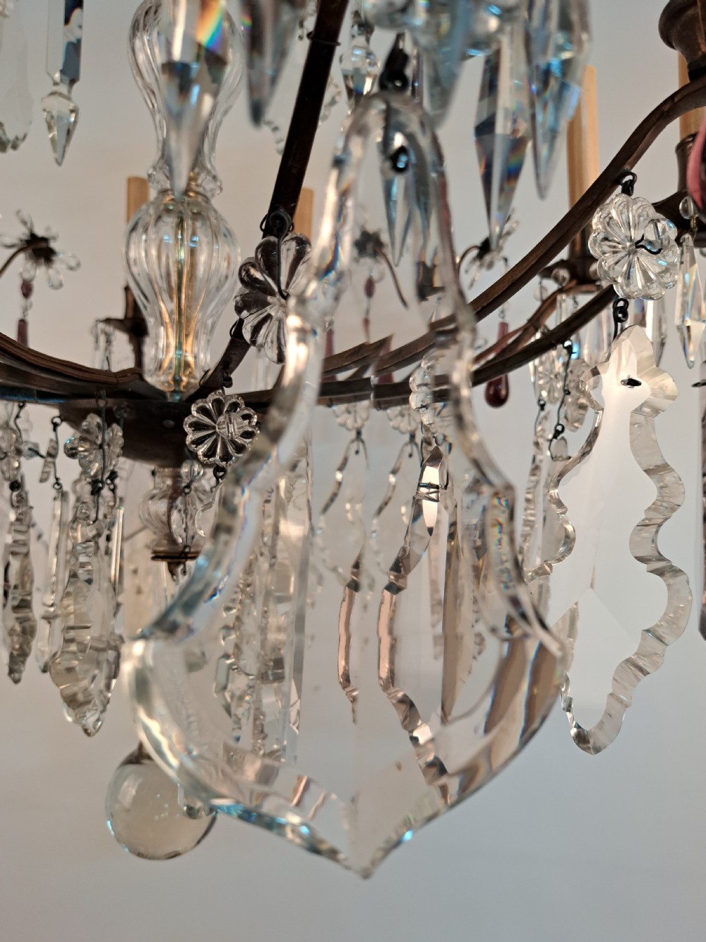 A multi-arm French crystal chandelier with candle-style light sockets, clear faceted glass prisms, and purple teardrop pendants on a dark wrought iron frame. View XXIII