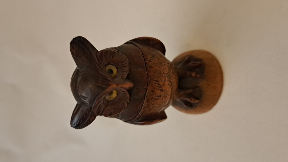 A small carved wooden owl inkwell featuring glass eyes and perched on a circular wooden base against a neutral background. View III