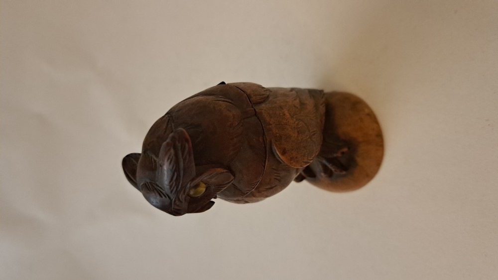 A small carved wooden owl inkwell featuring glass eyes and perched on a circular wooden base against a neutral background. View IV
