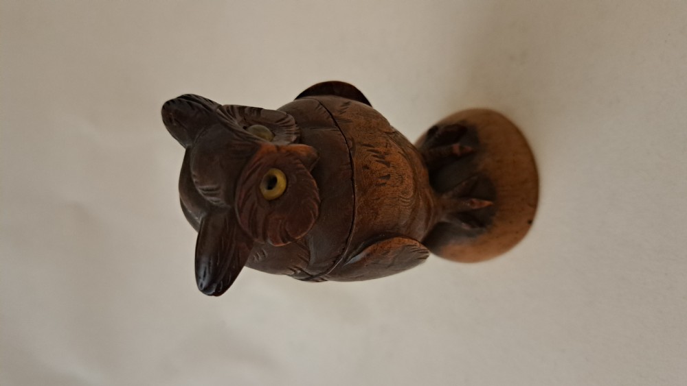 A small carved wooden owl inkwell featuring glass eyes and perched on a circular wooden base against a neutral background. View VIII