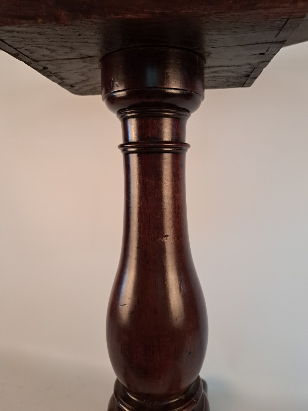 A Georgian mahogany tilt-top table with a circular timber top tilted vertically above a vase-turned pedestal stem and three cabriole legs. View XIV