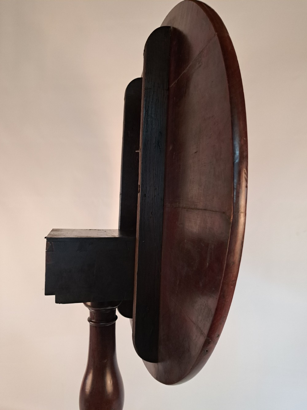 A Georgian mahogany tilt-top table with a circular timber top tilted vertically above a vase-turned pedestal stem and three cabriole legs. View XIX