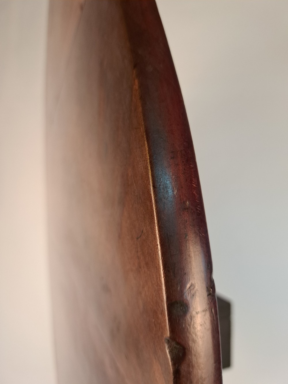 A Georgian mahogany tilt-top table with a circular timber top tilted vertically above a vase-turned pedestal stem and three cabriole legs. View XXI