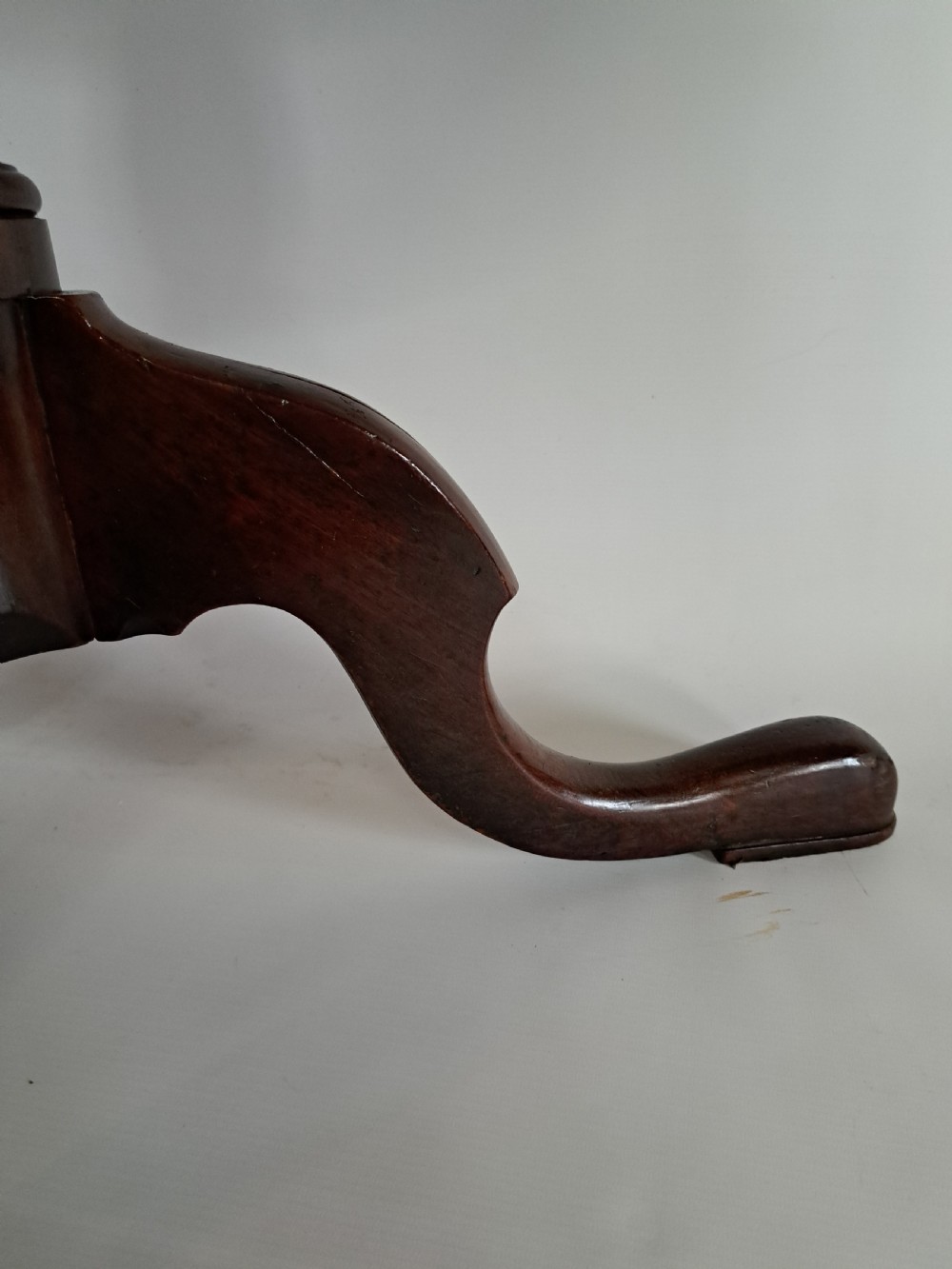 A Georgian mahogany tilt-top table with a circular timber top tilted vertically above a vase-turned pedestal stem and three cabriole legs. View XXV
