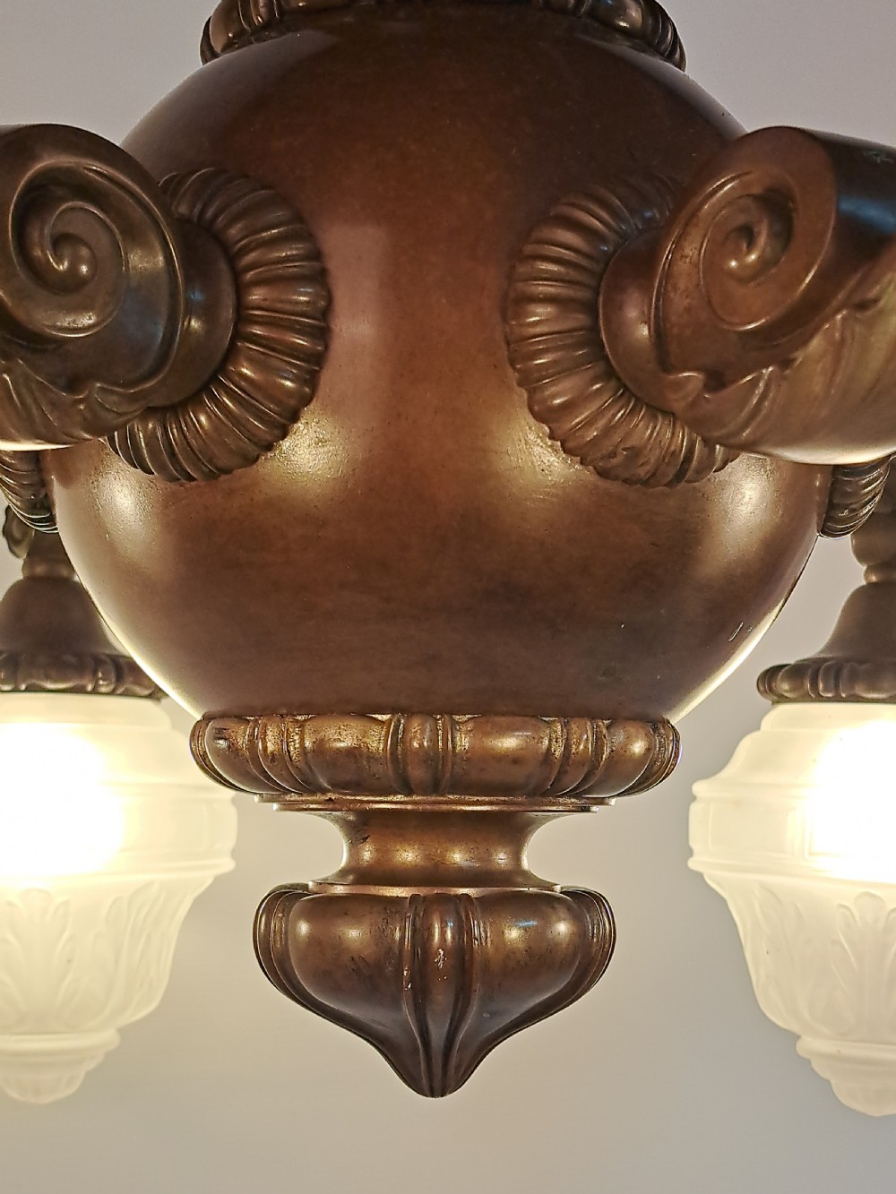 A five-arm dark bronze chandelier featuring a central turned stem, curved scroll arms, and downward-facing frosted glass shades. View XIV