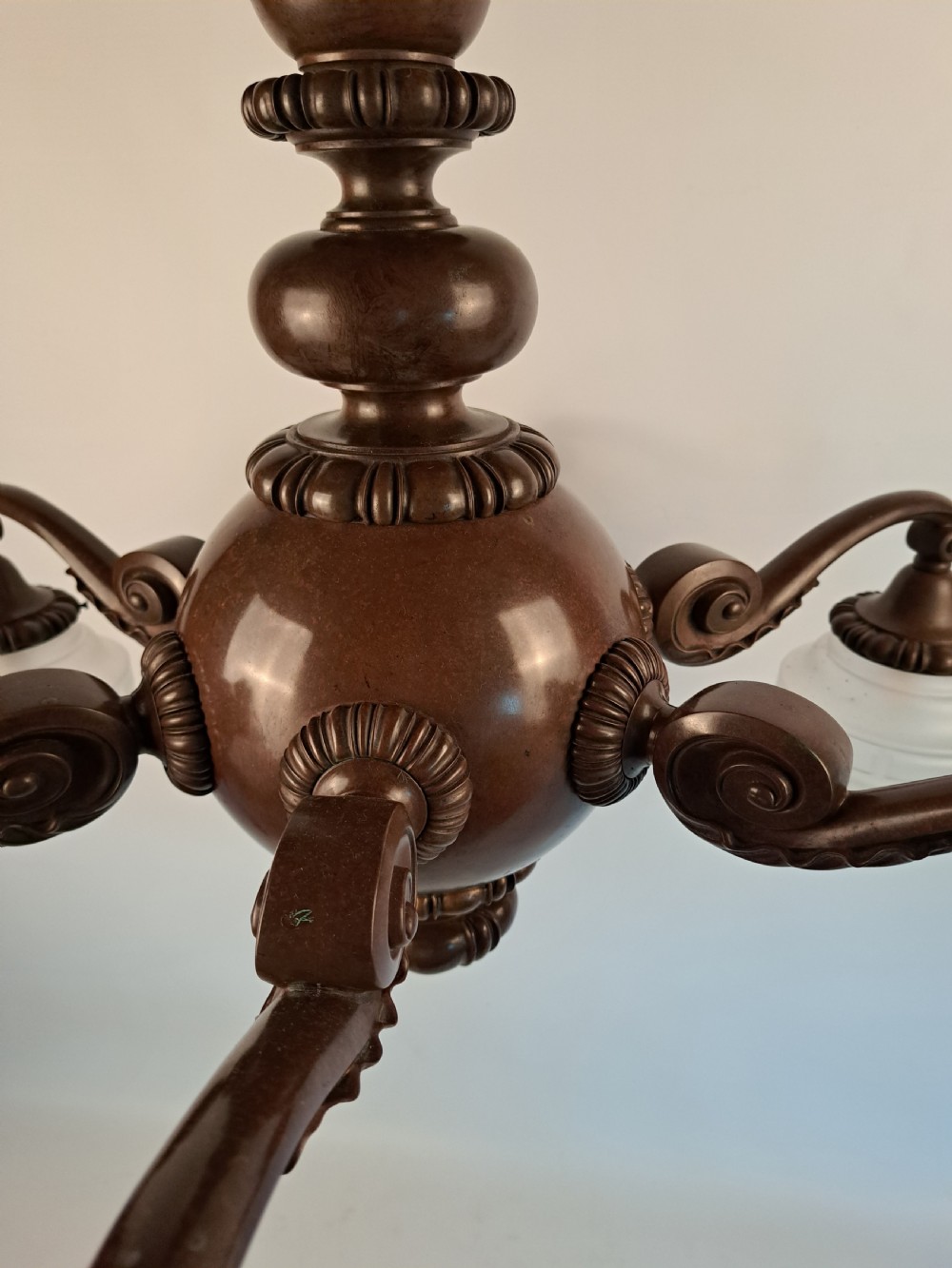 A five-arm dark bronze chandelier featuring a central turned stem, curved scroll arms, and downward-facing frosted glass shades. View XIX