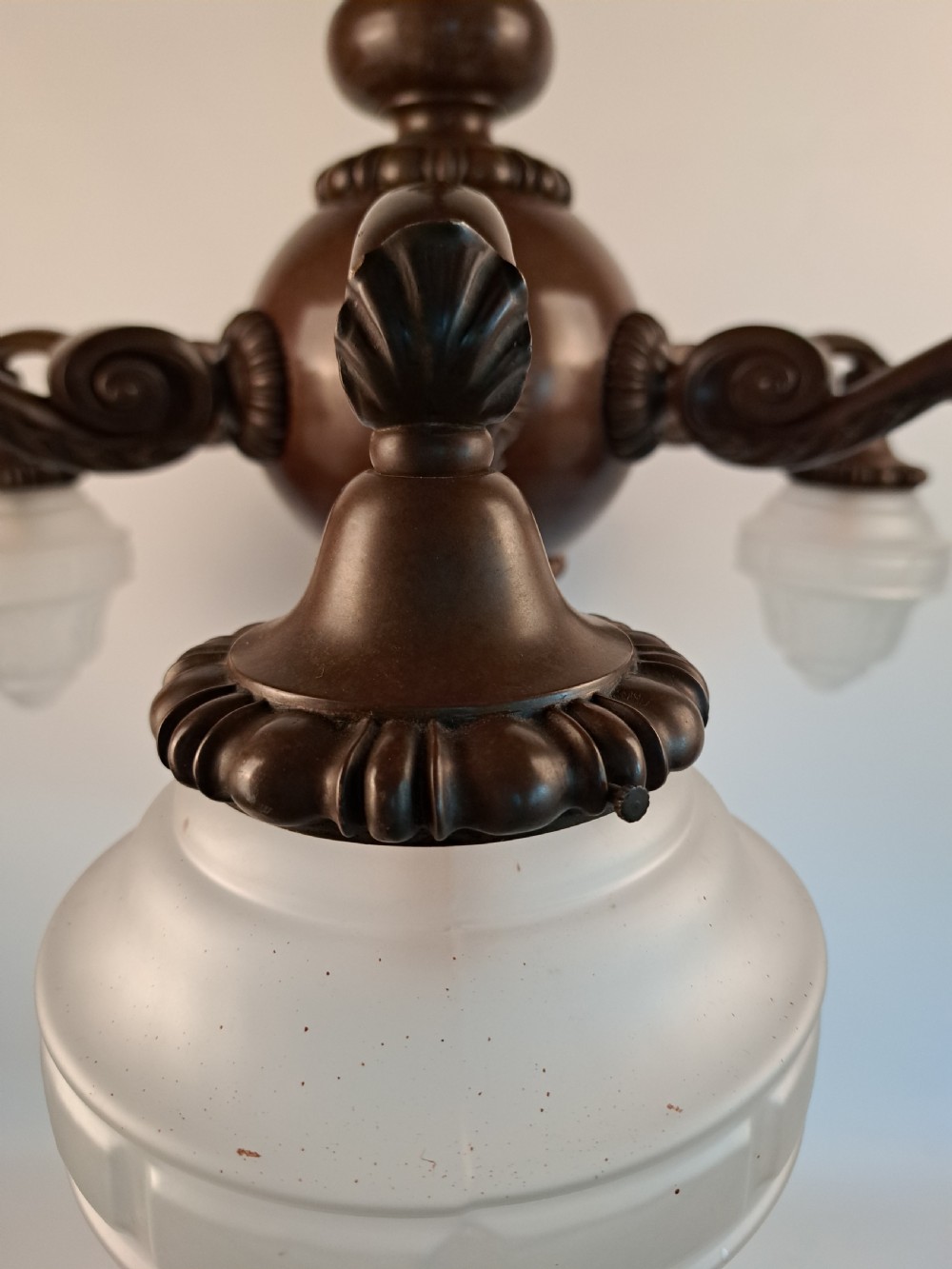 A five-arm dark bronze chandelier featuring a central turned stem, curved scroll arms, and downward-facing frosted glass shades. View XXIV