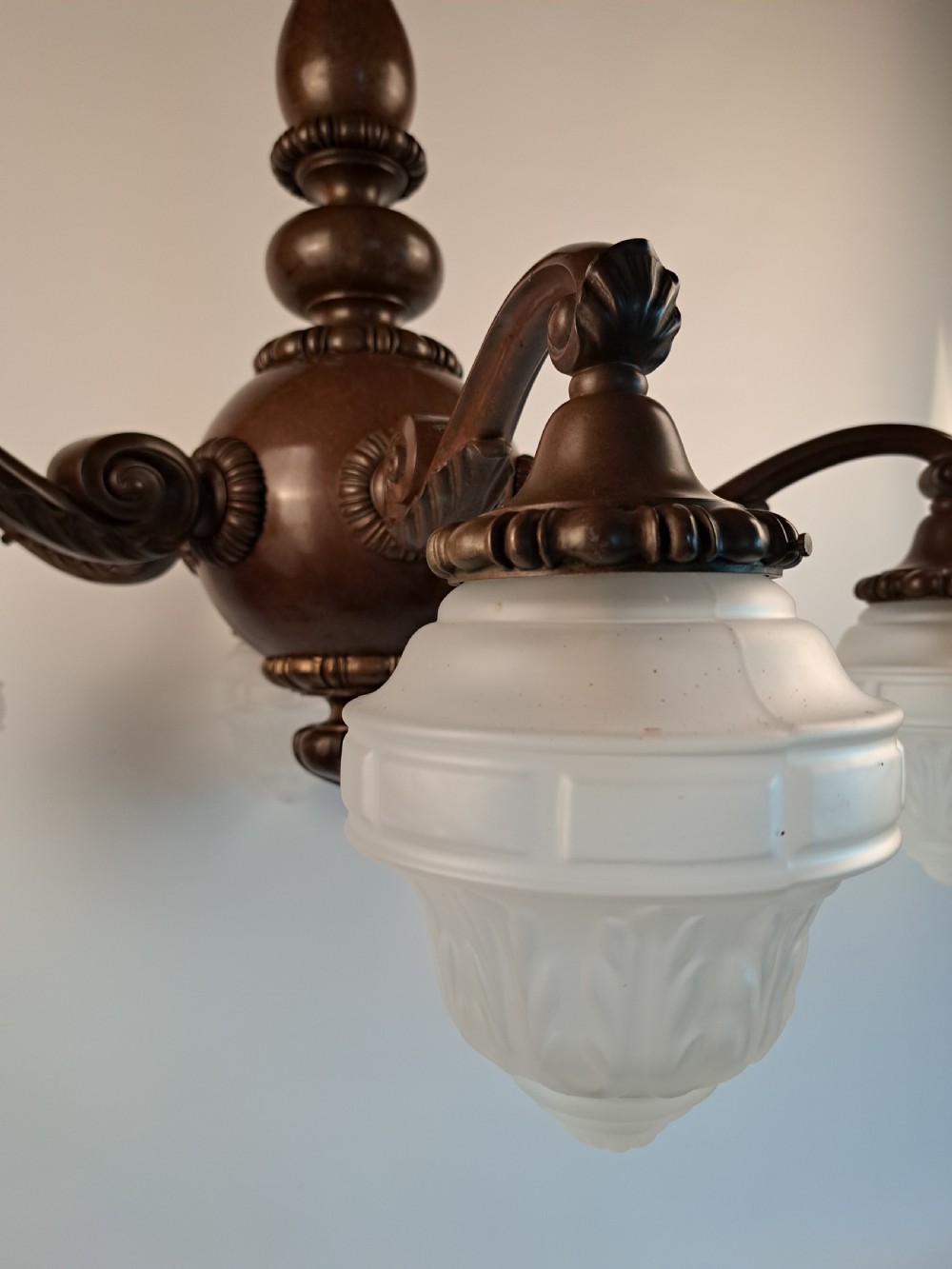 A five-arm dark bronze chandelier featuring a central turned stem, curved scroll arms, and downward-facing frosted glass shades. View XXV